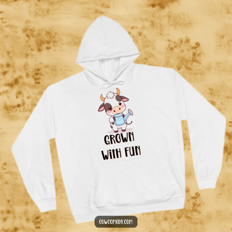 Funny kawaii cow hoodie showing a cute cow holding a tiny watering can with a playful demeanor, offering warmth and whimsy.
