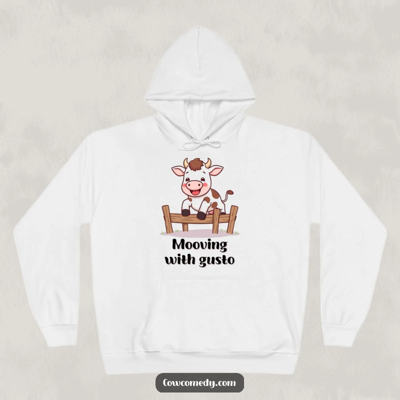 Funny kawaii cow hoodie showing a cute cow leaping energetically over a small fence, offering warmth and motivation.
