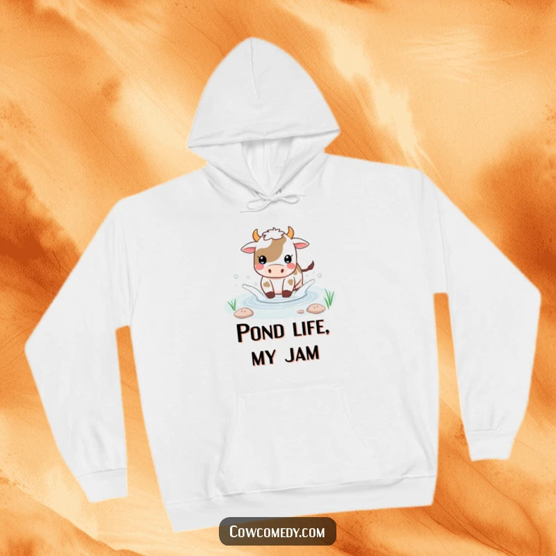 Funny Kawaii cow hoodie depicting a happy cow splashing water playfully in a small pond, full of watery joy.