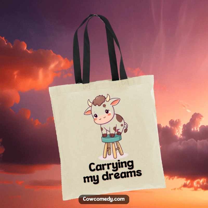 Funny tote bag showcasing a small, determined cow struggling to balance on a comically small stool, perfect for carrying groceries with a laugh.